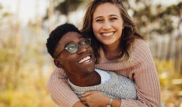 Young man carrying a young woman on his back