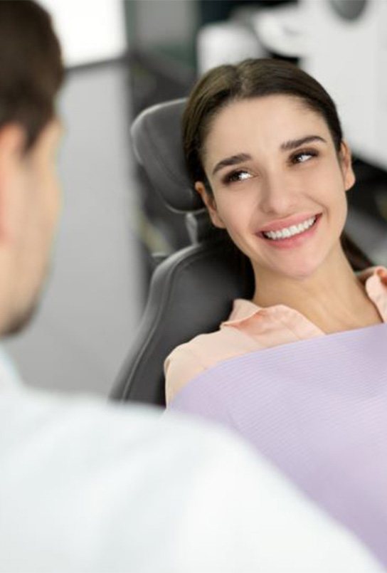 Smiling patient talking with cosmetic dentist