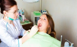 woman dentist making a review of patient mouth